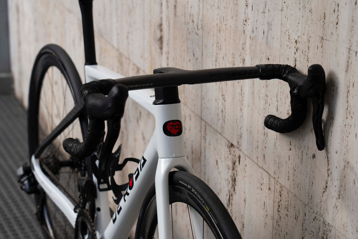 Front-end view of the integrated carbon cockpit and Campagnolo Super Record Wireless shifter levers on the De Rosa 70 white complete bicycle by Cicli Corsa.
